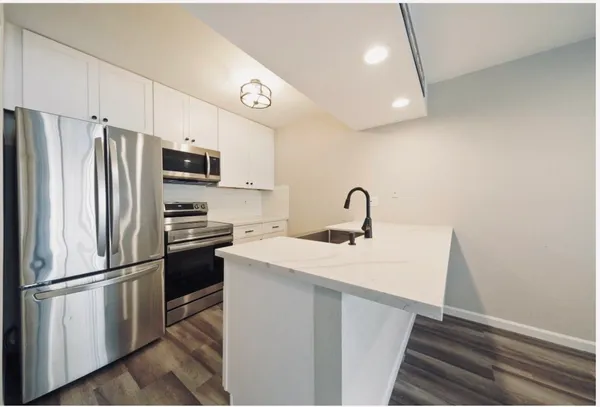 a kitchen with stainless steel appliances a refrigerator sink and microwave