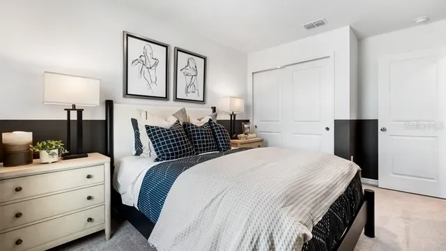 a bedroom with a bed and painting on the wall