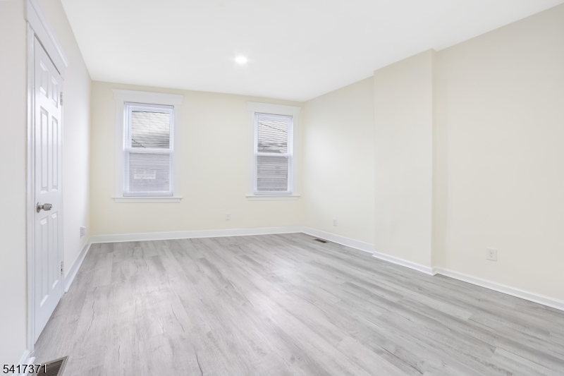 88 Devon Street Kearny, NJ 07032 - Photo 13 of 16 an empty room with wooden floor and windows