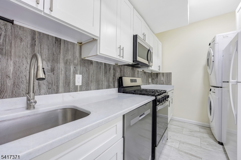 88 Devon Street Kearny, NJ 07032 - Photo 14 of 16 a kitchen with stainless steel appliances granite countertop a sink stove and refrigerator