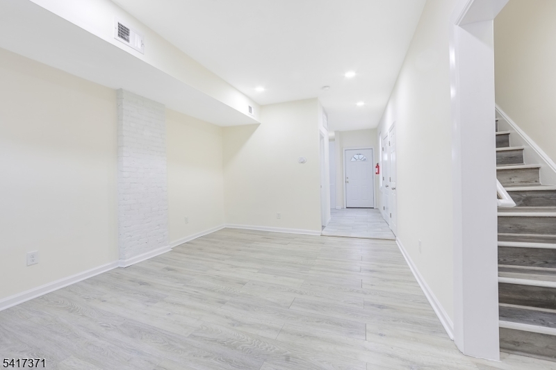 88 Devon Street Kearny, NJ 07032 - Photo 3 of 16 an empty room with wooden floor and windows