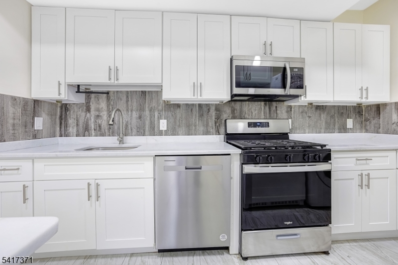 88 Devon Street Kearny, NJ 07032 - Photo 6 of 16 a kitchen with white cabinets and appliances
