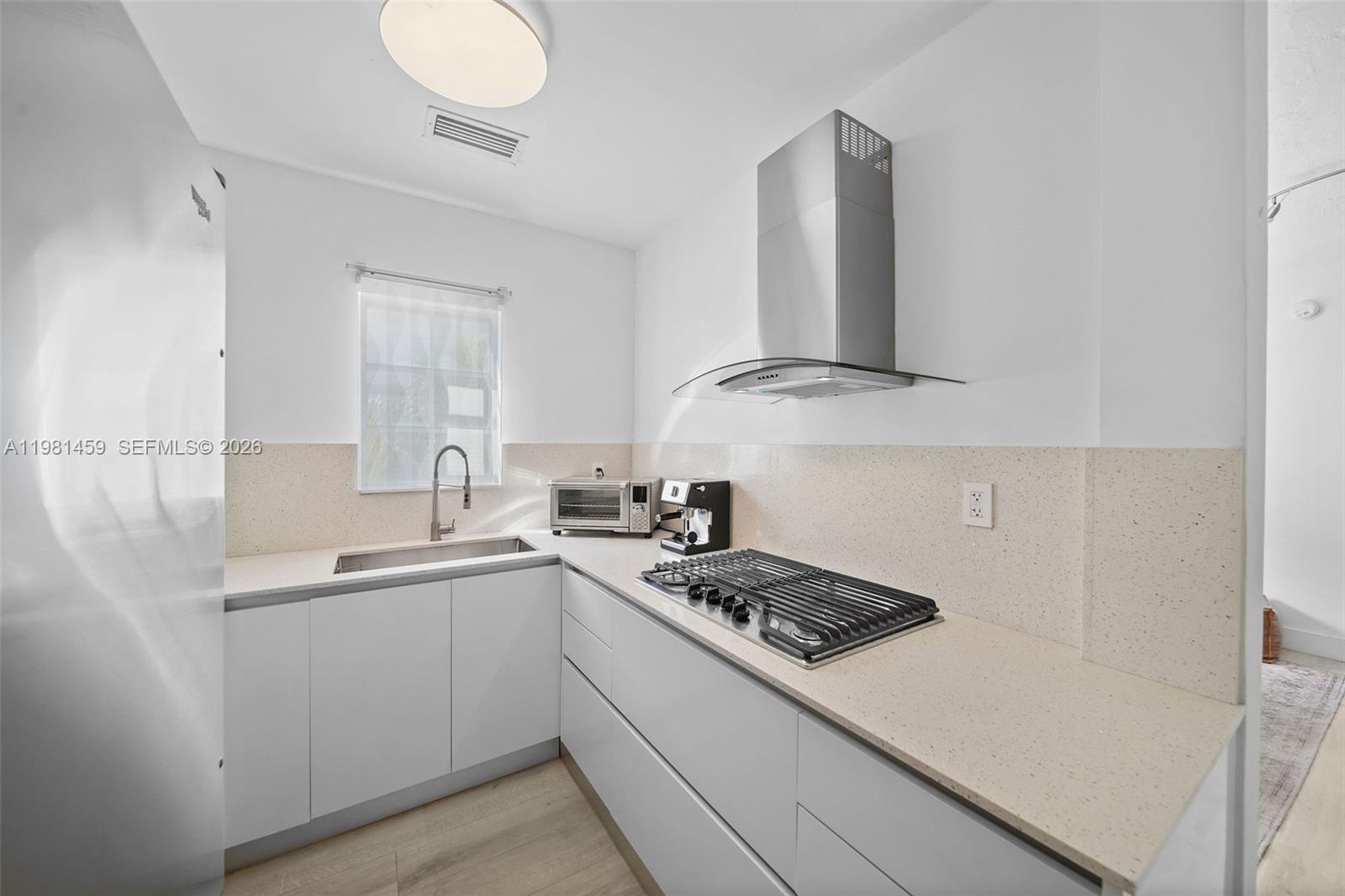 832 15th Street, Unit 4 Miami Beach, FL 33139 - Photo 13 of 17 a kitchen with a sink a stove and cabinets