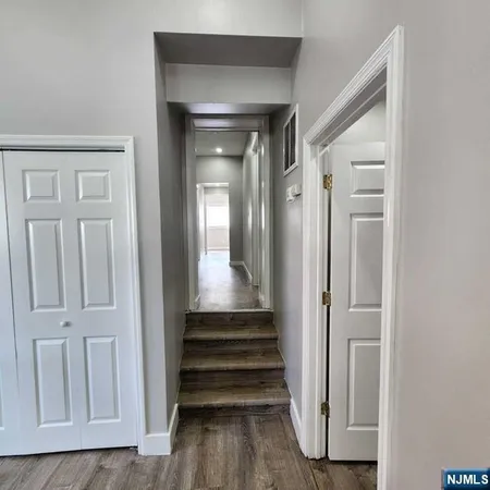 a view of a hallway with wooden floor and entryway