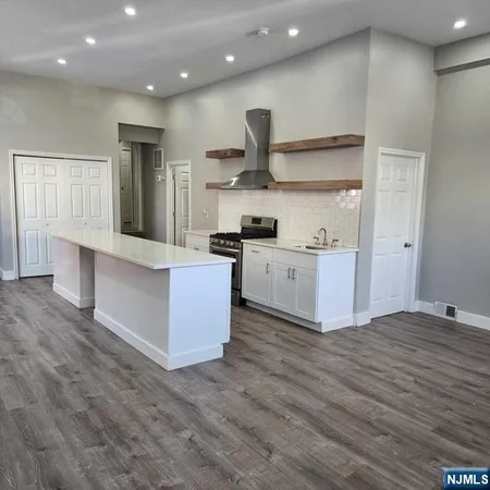 a large kitchen with stainless steel appliances granite countertop a large counter top and a stove top oven