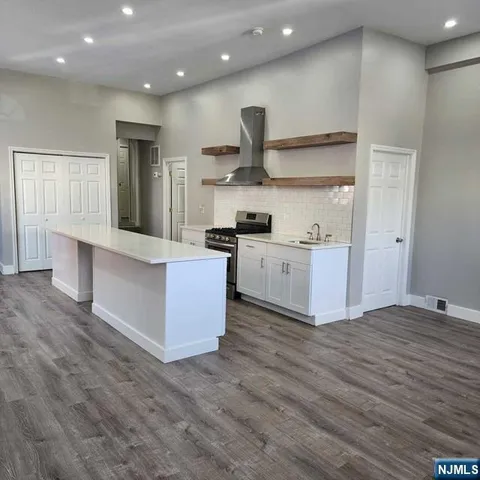 a large kitchen with stainless steel appliances granite countertop a large counter top and a stove top oven