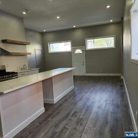 a view of a kitchen with wooden floor and staircase