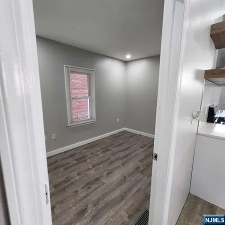 a view of hallway with a window and wooden floor
