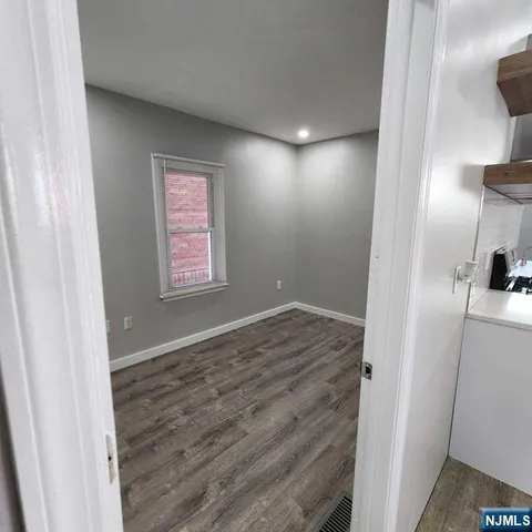 a view of hallway with a window and wooden floor