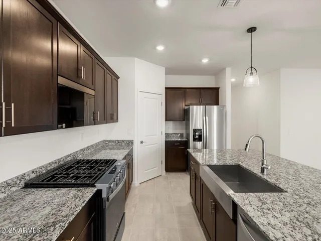 a kitchen with stainless steel appliances granite countertop a sink stove and refrigerator
