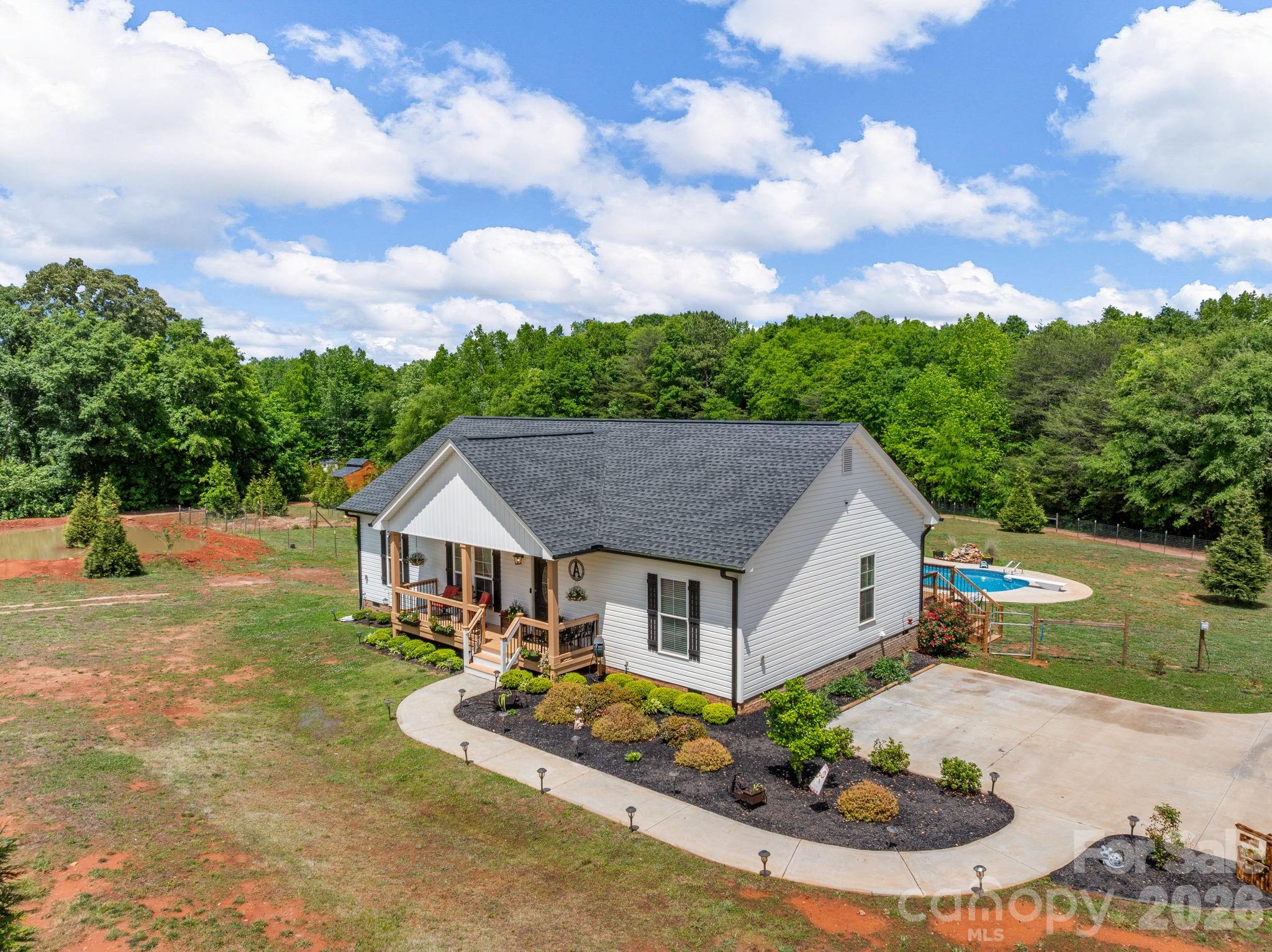 1076 McSwain Road Chesnee, SC 29323 - Photo 2 of 36 a aerial view of a house with table and chairs under an umbrella