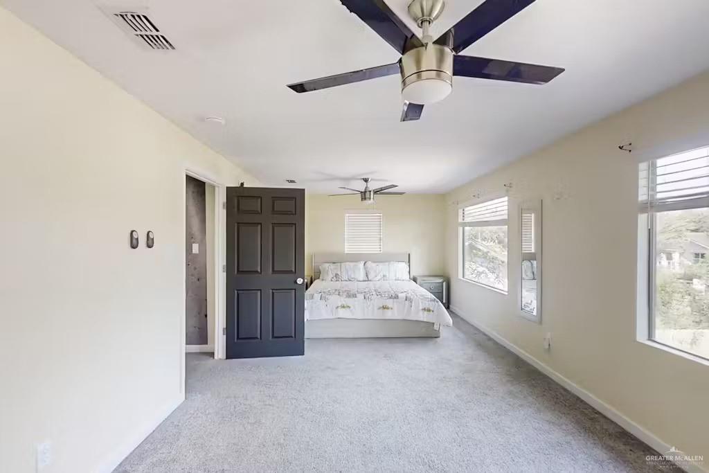 2153 El Rancho Road McAllen, TX 78503 - Photo 22 of 36 a spacious bedroom with a bed and a chandelier
