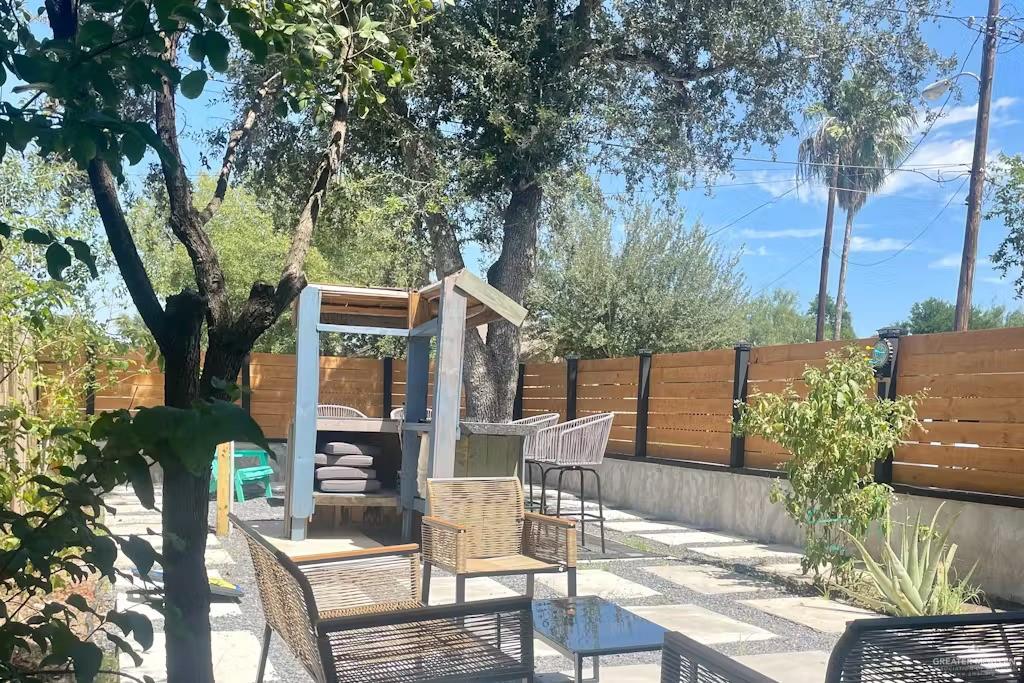 2153 El Rancho Road McAllen, TX 78503 - Photo 27 of 36 a view of a patio with table and chairs potted plants and large tree