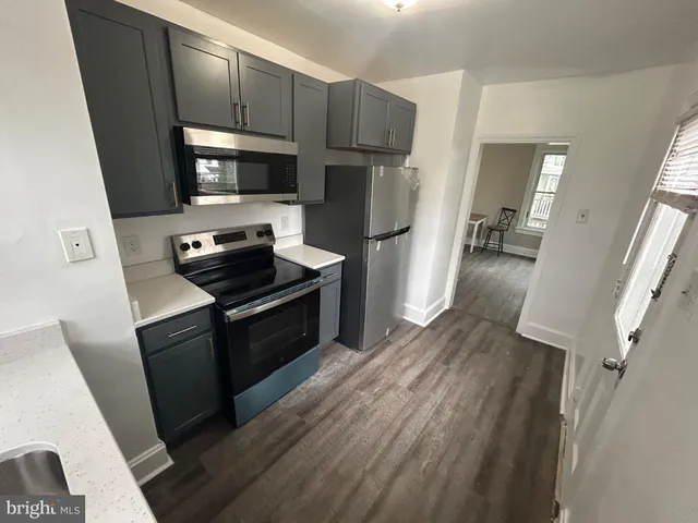 a kitchen with stainless steel appliances a stove a refrigerator a sink a stove a microwave and cabinets