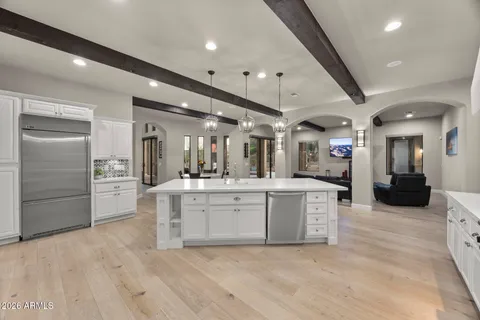 a large white kitchen with a large counter top and stainless steel appliances
