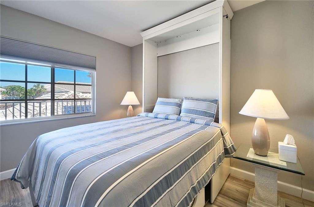 9022 Michael Circle, Unit 2210 Naples, FL 34113 - Photo 13 of 36 a bedroom with a bed and a lamp