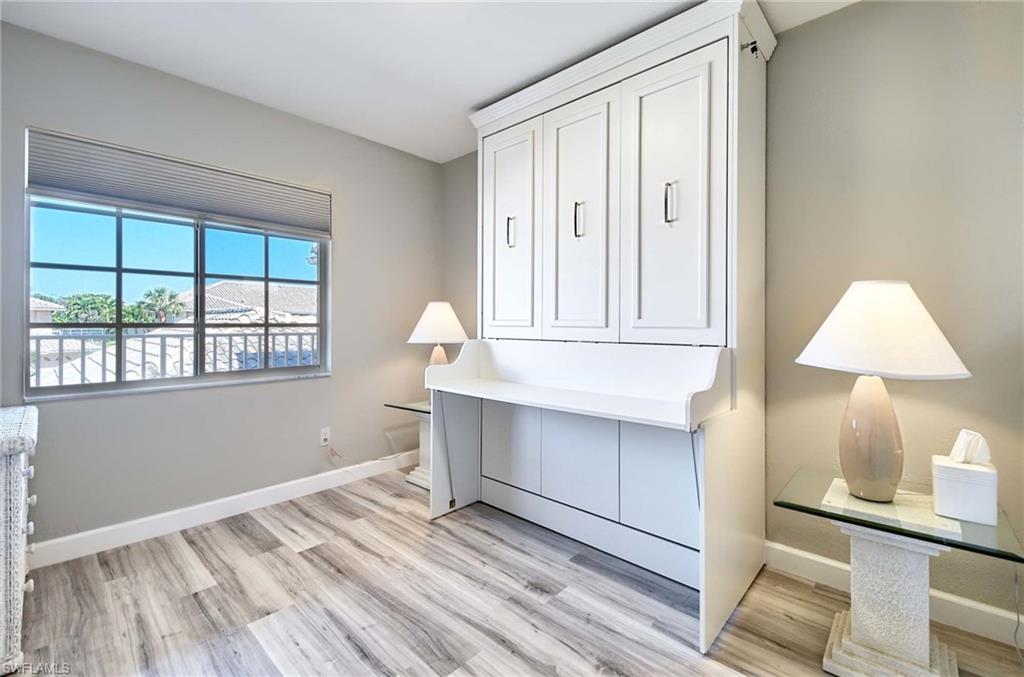 9022 Michael Circle, Unit 2210 Naples, FL 34113 - Photo 14 of 36 wooden floor in an empty room with a window