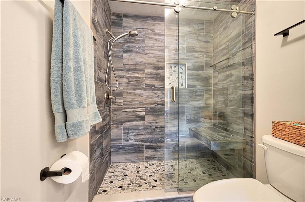 9022 Michael Circle, Unit 2210 Naples, FL 34113 - Photo 21 of 36 a bathroom with a toilet and a shower