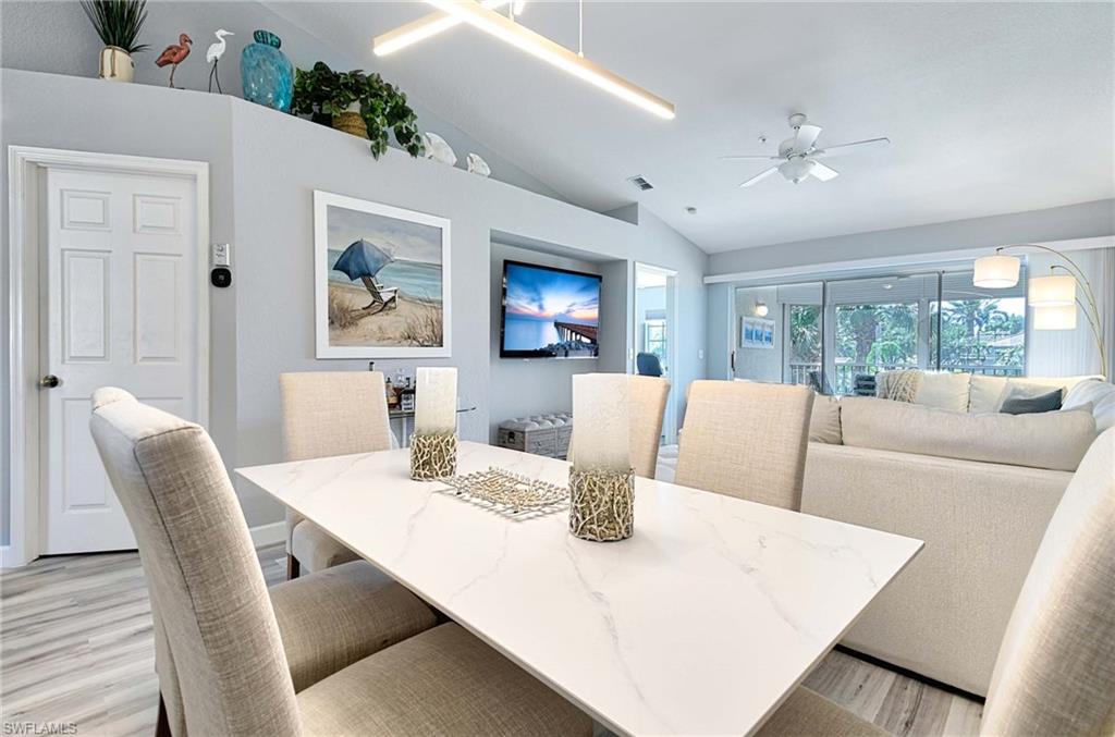 9022 Michael Circle, Unit 2210 Naples, FL 34113 - Photo 4 of 36 a living room with furniture a chandelier and a dining table
