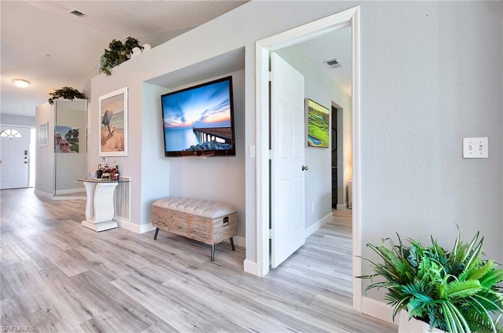 9022 Michael Circle, Unit 2210 Naples, FL 34113 - Photo 7 of 36 a view of a hallway with wooden floor and a livingroom