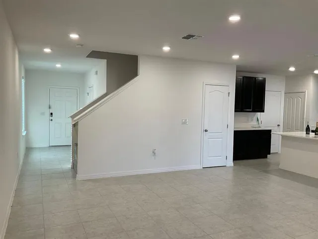 a view of an empty room with a kitchen