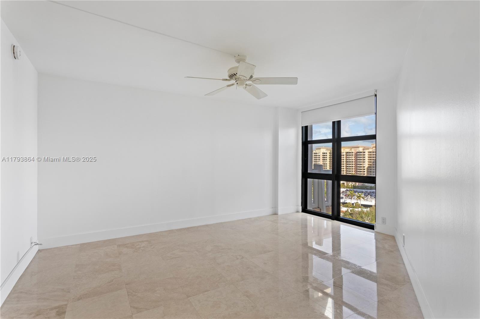 1121 Crandon Boulevard, Unit E1204 Key Biscayne, FL 33149 - Photo 12 of 21 an empty room with windows and ceiling fan