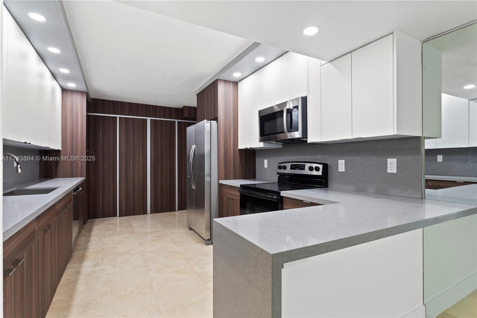 1121 Crandon Boulevard, Unit E1204 Key Biscayne, FL 33149 - Photo 4 of 21 a kitchen with stainless steel appliances a refrigerator stove microwave and sink