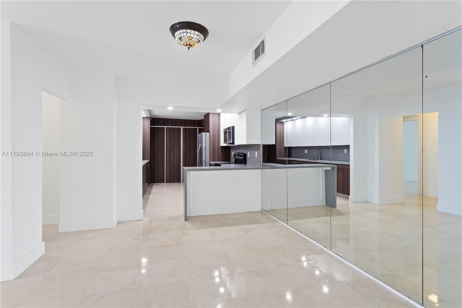 1121 Crandon Boulevard, Unit E1204 Key Biscayne, FL 33149 - Photo 7 of 21 a large kitchen with stainless steel appliances a refrigerator and a stove top oven