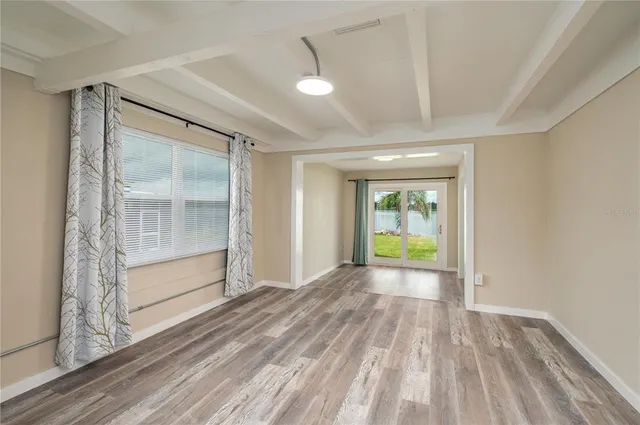 a view of an empty room with closet and a bathroom