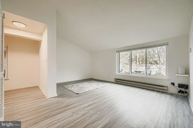 a kitchen with granite countertop a refrigerator stove and wooden floor