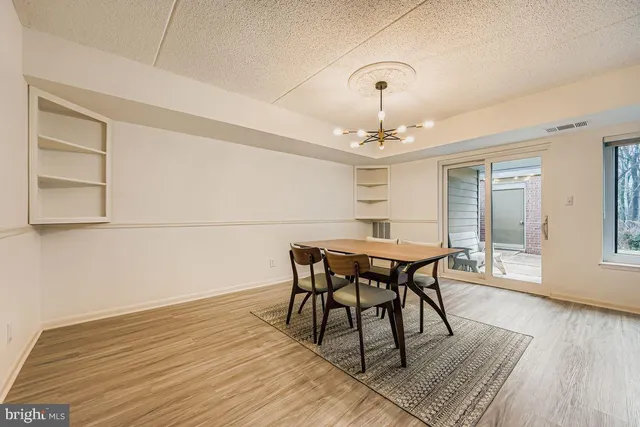 a kitchen with stainless steel appliances granite countertop a stove top oven a sink dishwasher and a refrigerator with wooden floor