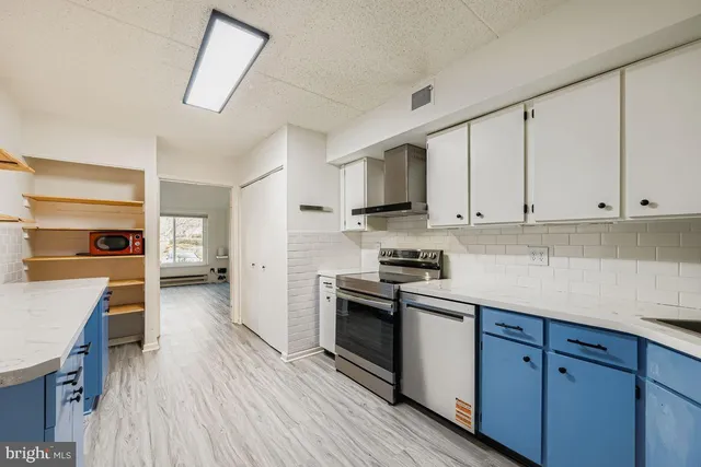 a kitchen with kitchen island wooden floors and wooden cabinets
