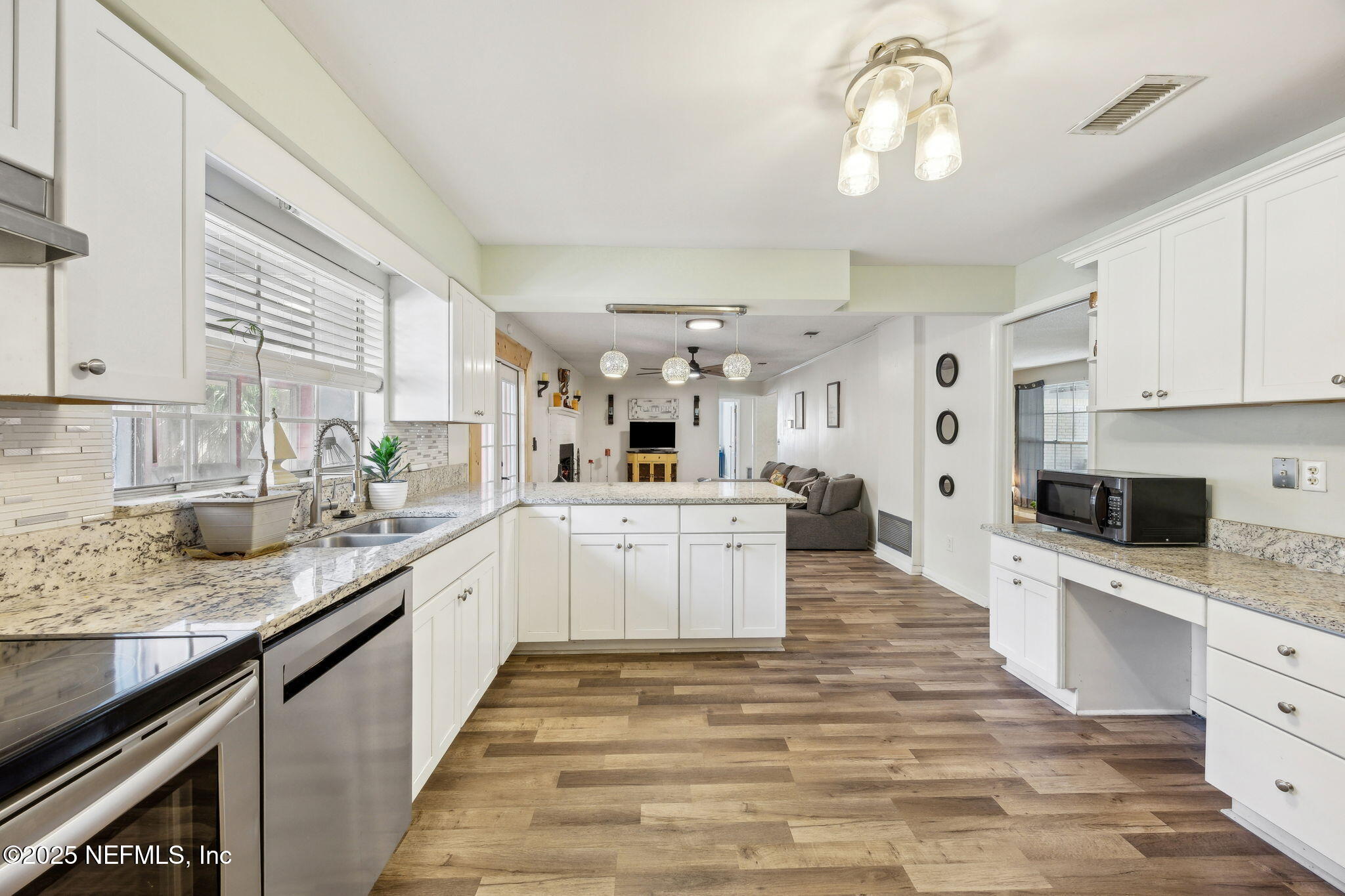 6305 Wuthering Heights Road Jacksonville, FL 32211 - Photo 26 of 53 a large kitchen with stainless steel appliances granite countertop a stove sink and cabinets