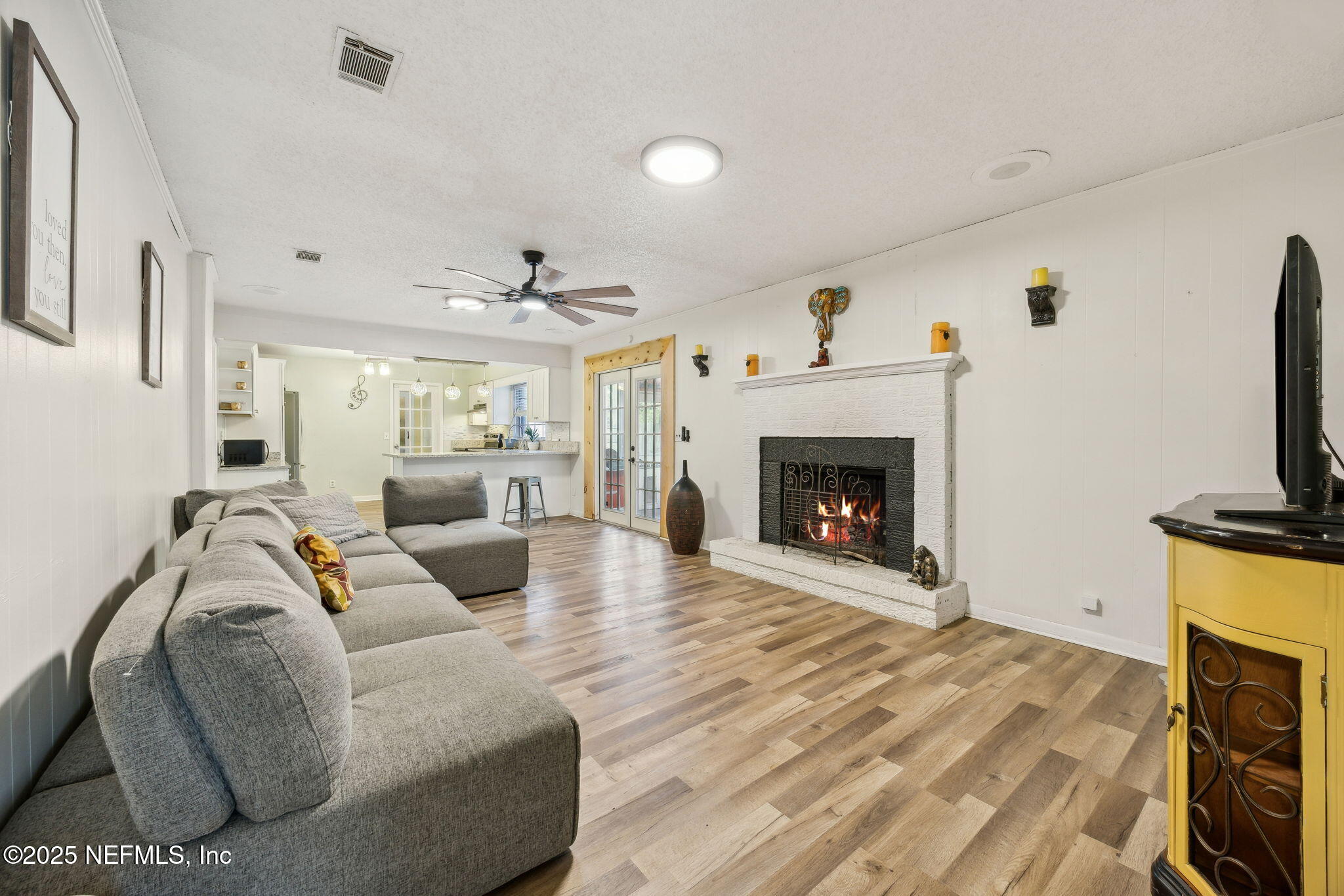 6305 Wuthering Heights Road Jacksonville, FL 32211 - Photo 30 of 52 a living room with furniture a fireplace and a flat screen tv