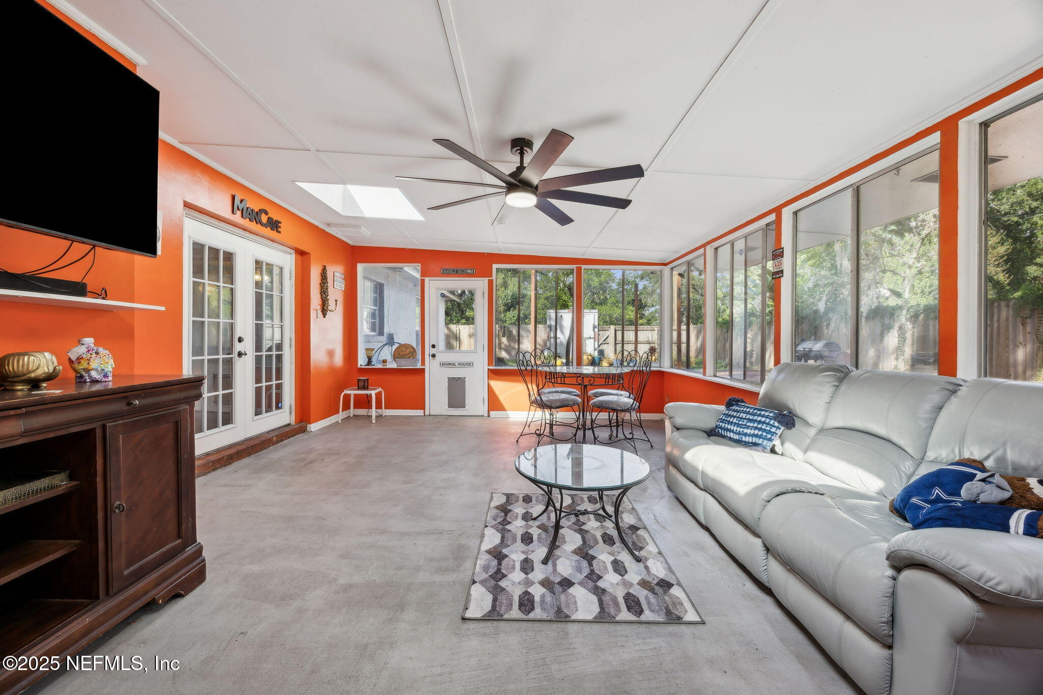 6305 Wuthering Heights Road Jacksonville, FL 32211 - Photo 35 of 52 a living room with furniture a flat screen tv and a floor to ceiling window