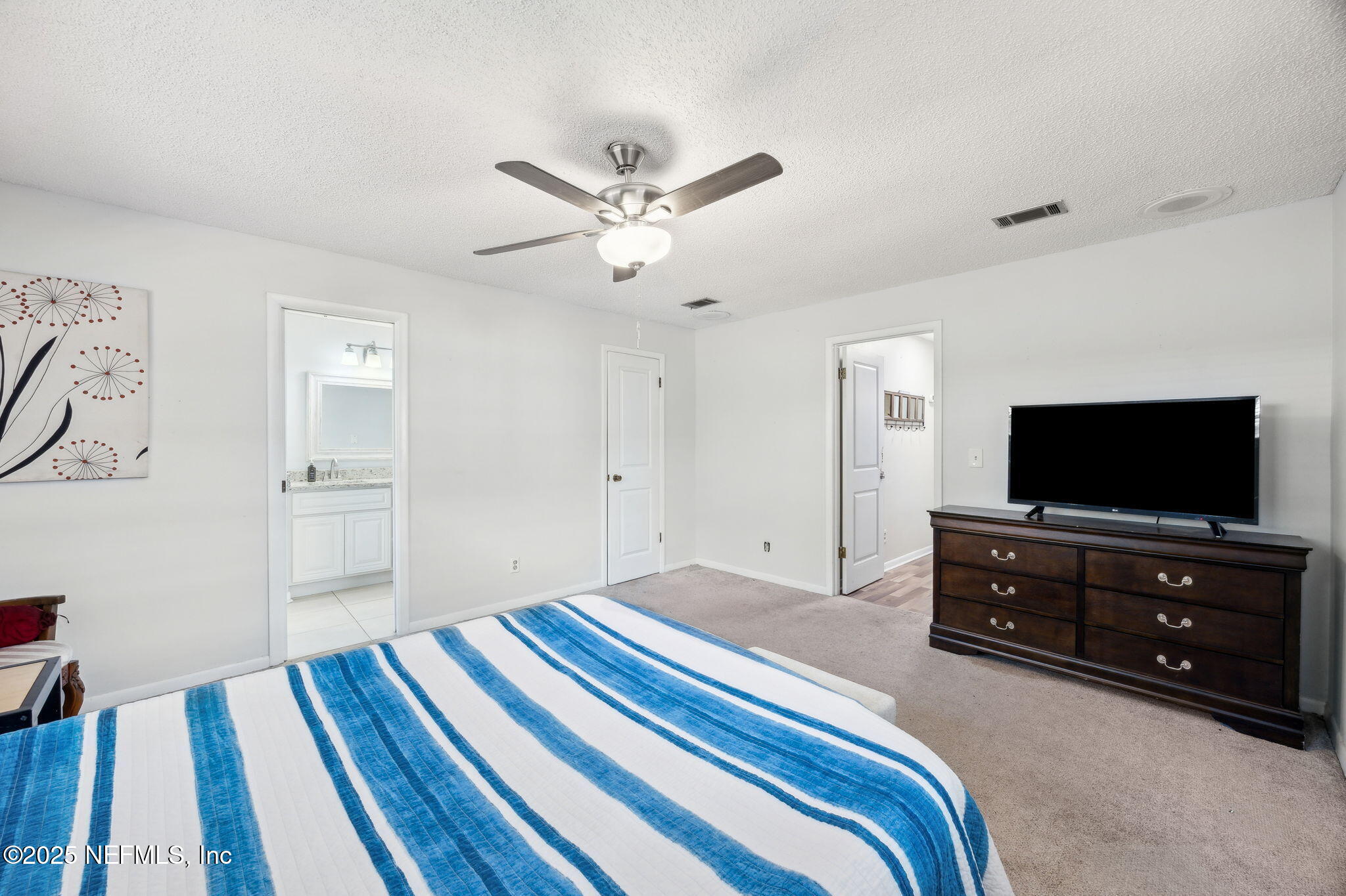 6305 Wuthering Heights Road Jacksonville, FL 32211 - Photo 38 of 52 a bedroom with a bed and a flat screen tv