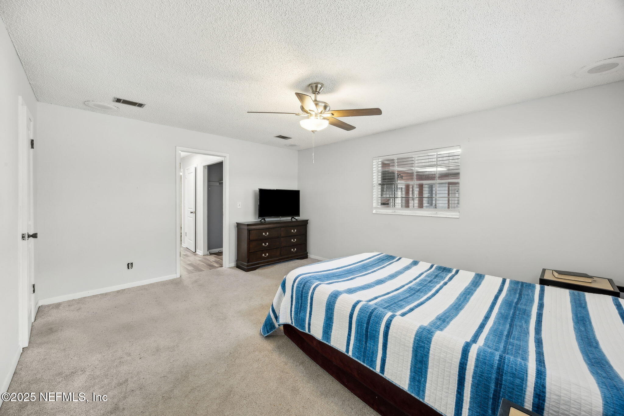 6305 Wuthering Heights Road Jacksonville, FL 32211 - Photo 39 of 52 a spacious bedroom with a bed and a tv