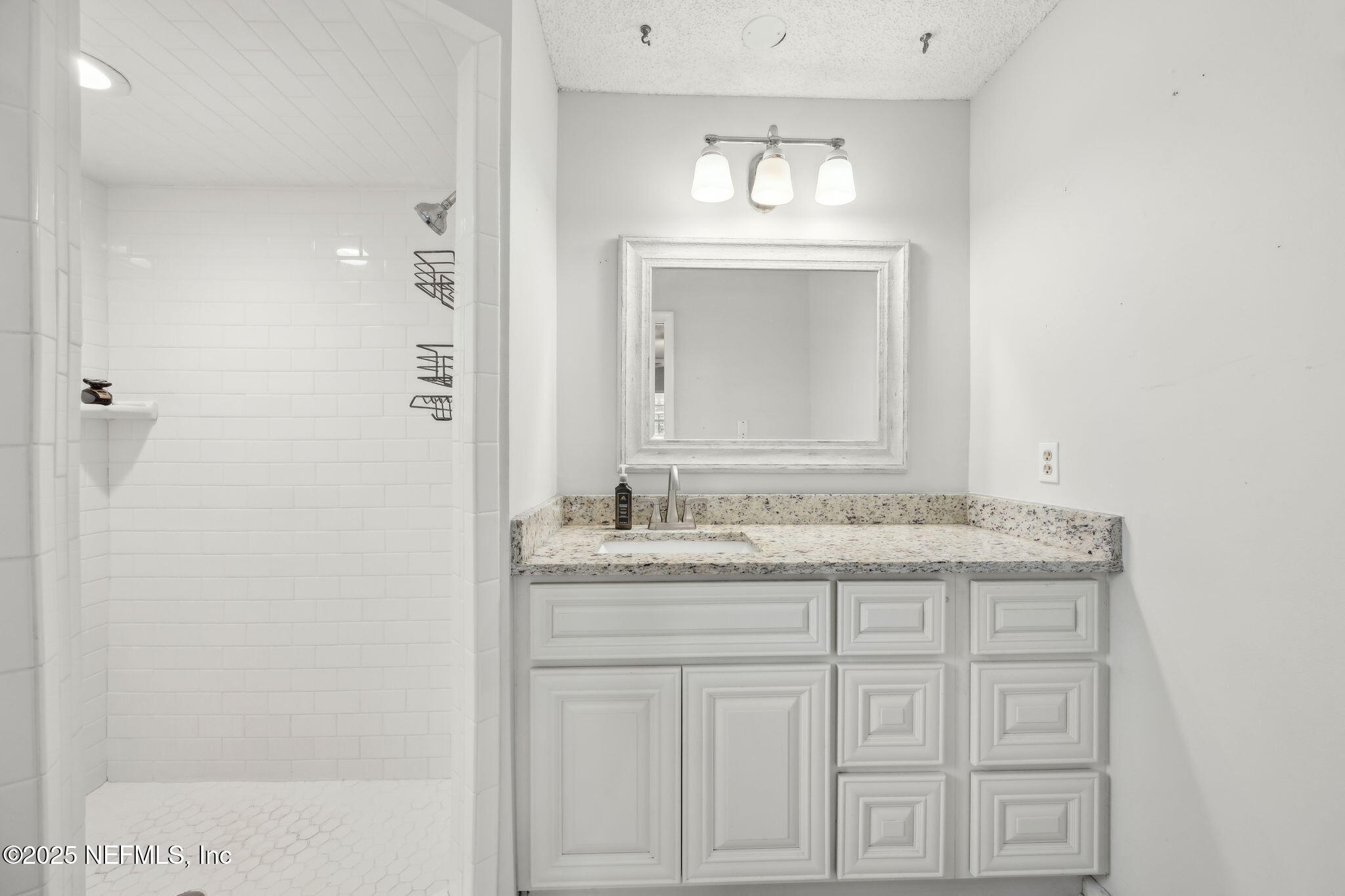 6305 Wuthering Heights Road Jacksonville, FL 32211 - Photo 40 of 52 a bathroom with a granite countertop sink a light fixture and a mirror