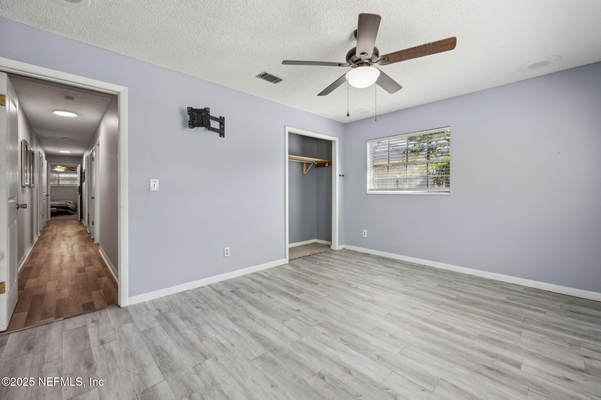 6305 Wuthering Heights Road Jacksonville, FL 32211 - Photo 48 of 53 a view of an empty room with wooden floor and a ceiling fan