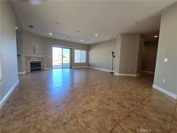an empty room with fireplace and windows
