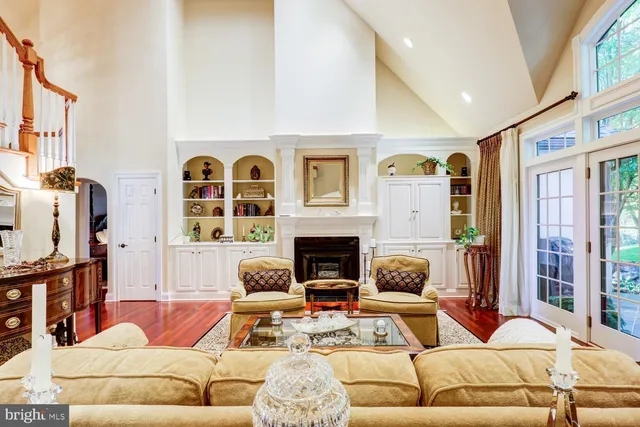 a bedroom with a bed a potted plant on dresser and a wooden floor