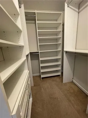 a view of walk in closet with empty racks