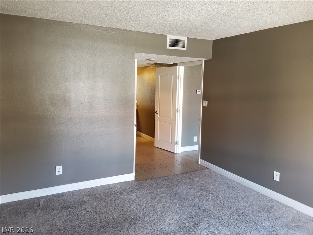 1515 East Reno Avenue, Unit A103 Las Vegas, NV 89119 - Photo 15 of 16 A spacious room offers neutral walls and plush carpeting, inviting personalized touches.