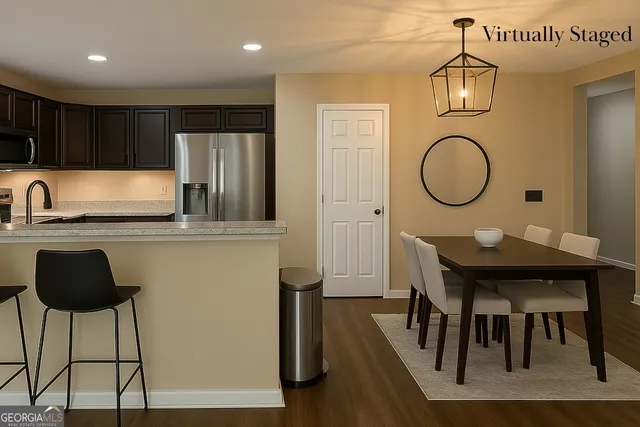 a kitchen with granite countertop a table chairs stove and a sink