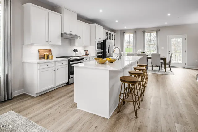 a kitchen with granite countertop white cabinets and stainless steel appliances