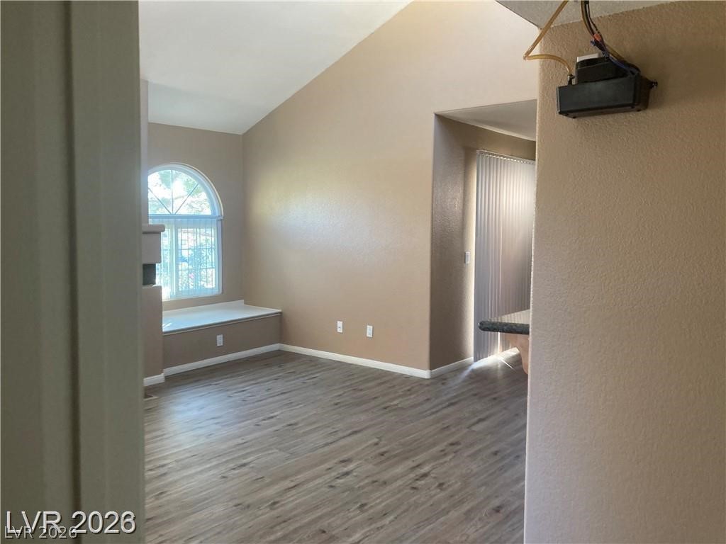 3145 East Flamingo Road, Unit 2100 Las Vegas, NV 89121 - Photo 14 of 34 Natural light floods this living area through a graceful arched window, highlighting the attractive plank flooring.