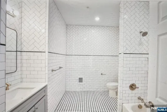 a bathroom with a sink a toilet a mirror and shower