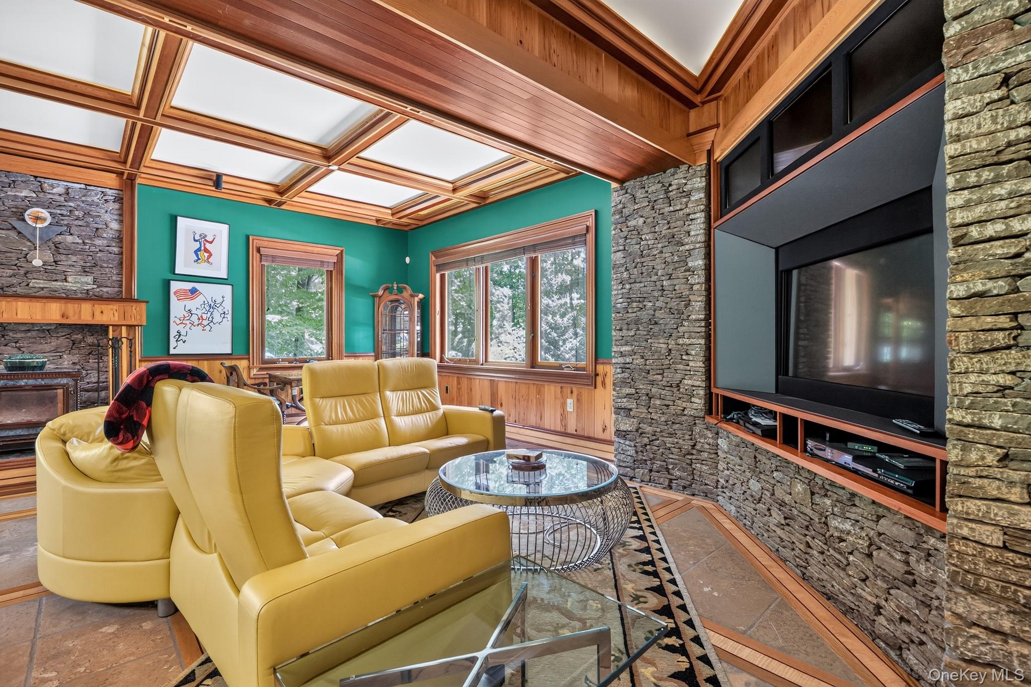 23 Inningwood Road Ossining, NY 10562 - Photo 17 of 50 Living area featuring a coffered wood-panel ceiling, stone-clad fireplace with a wood mantel, and built-in media center with stone surround