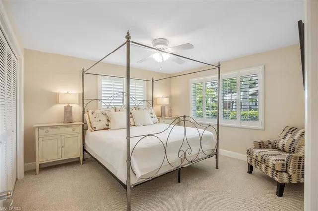 a bed sitting in a bedroom next to a window