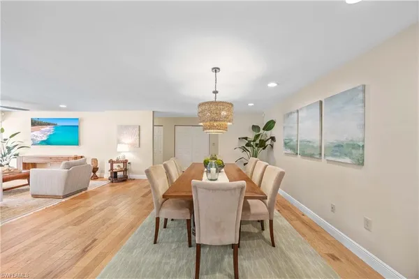 a dining room with furniture wooden floor a rug and a chandelier